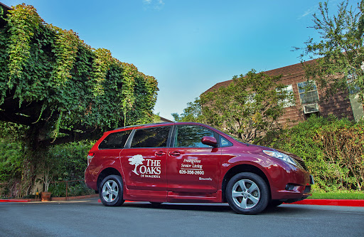 A red minivan showcasing promotional branding parked in a residential area.