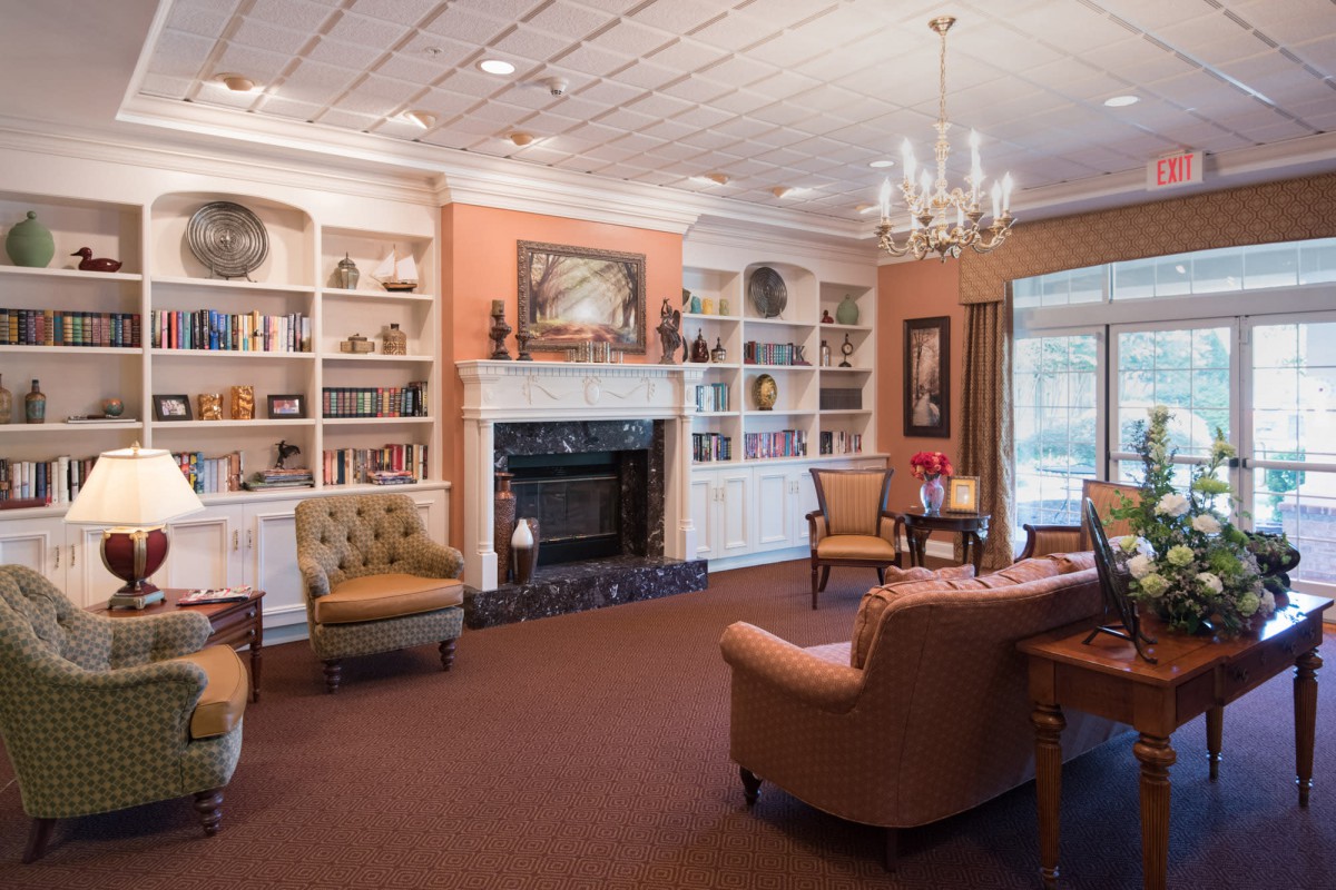 A cozy living room featuring a fireplace, elegant bookshelves, and comfortable seating arrangements.
