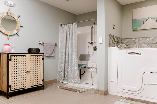 A modern bathroom featuring a shower with a curtain, a towel rack, and storage cabinets.
