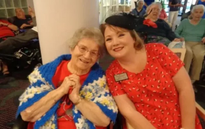 Two women smiling and enjoying each other's company indoors.