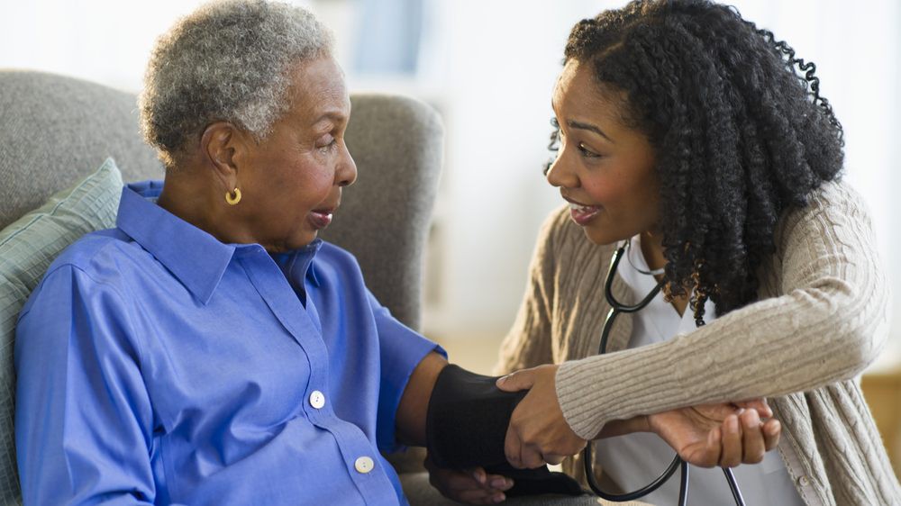 A healthcare professional measures a patient's blood pressure.