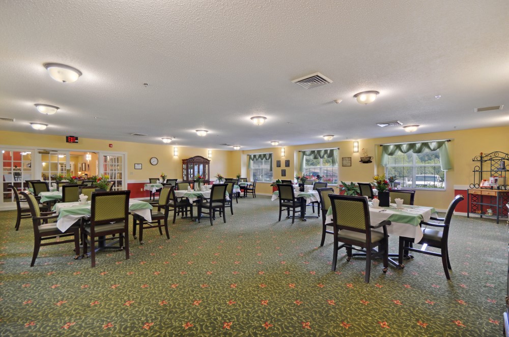 A spacious and well-lit dining room with neatly arranged tables and chairs.