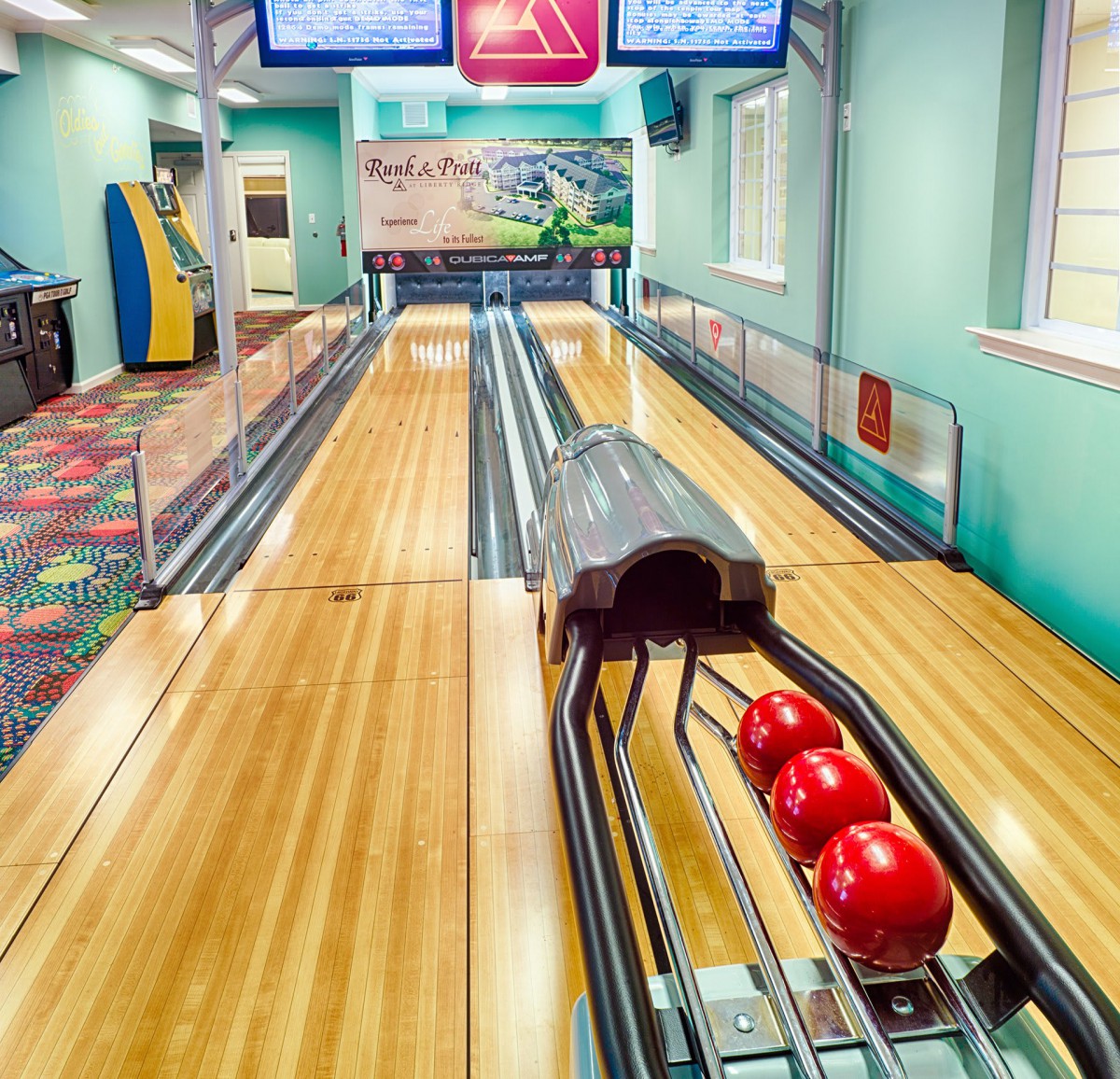 A vibrant indoor bowling alley with lanes and red bowling balls ready for play.