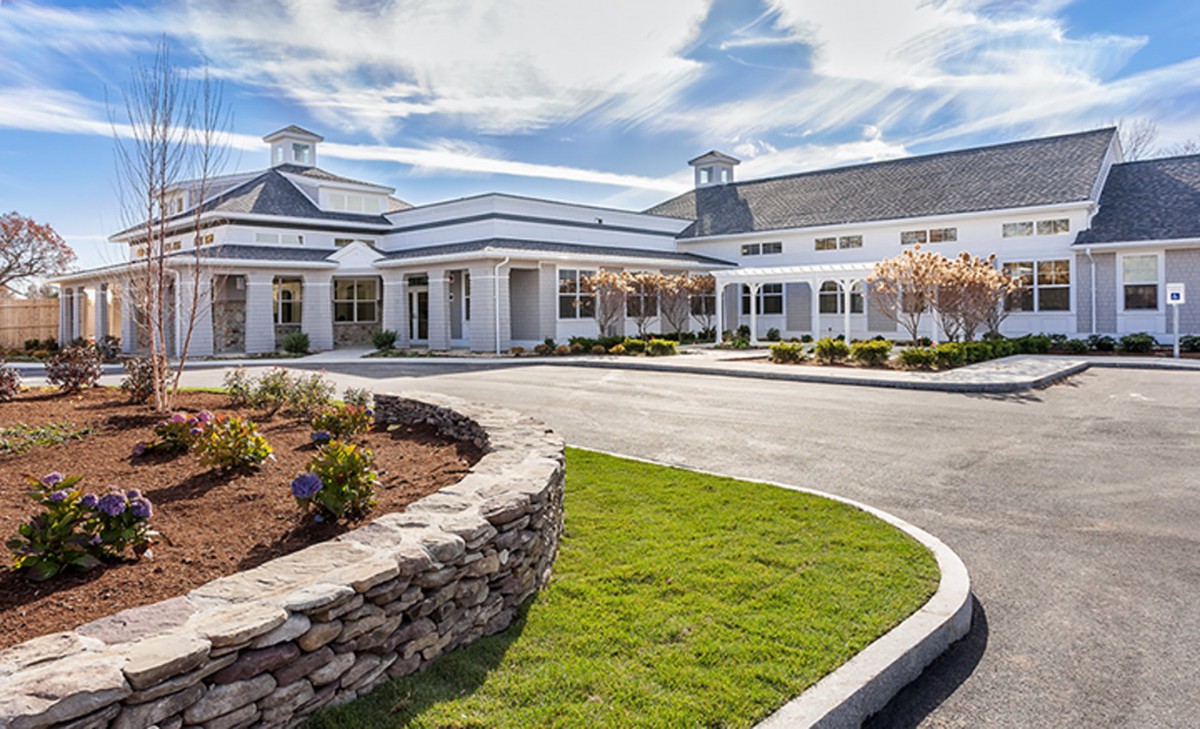 A well-designed building with a landscaped entrance and clear blue sky.