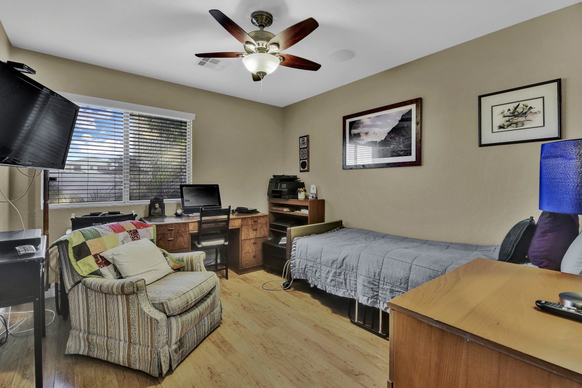 A cozy bedroom with a desk, computer, and comfortable seating.