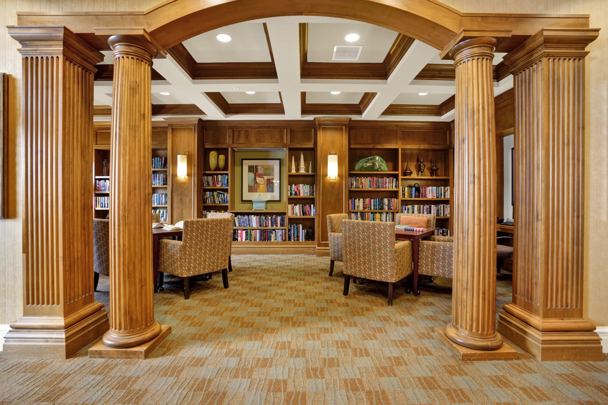 A cozy library interior with wooden columns and bookshelves.
