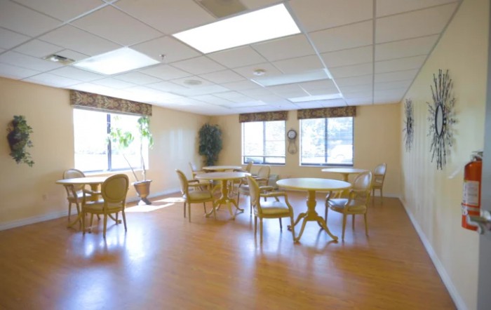 A bright and spacious dining area with tables, chairs, and large windows letting in natural light.