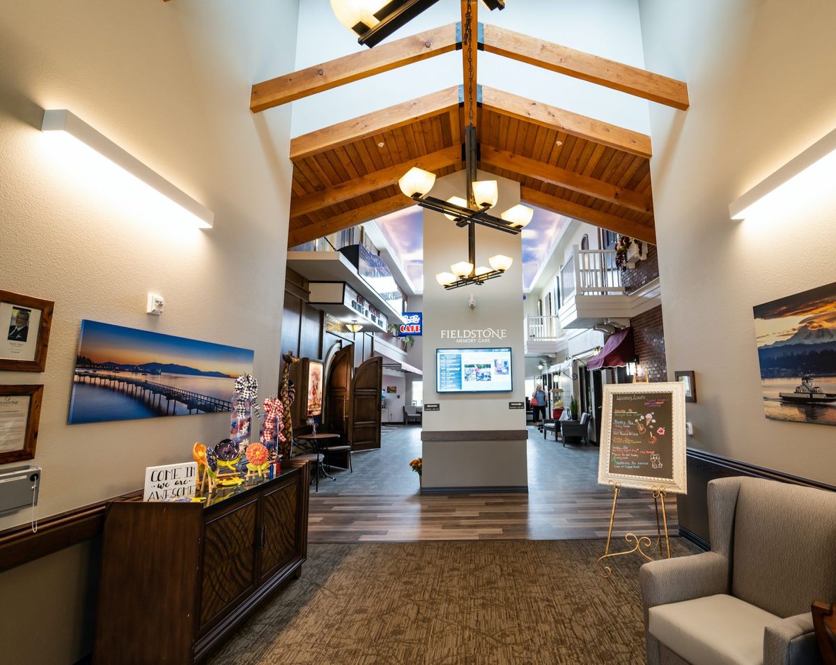 A modern lobby with wooden beams, a chandelier, and comfortable seating.