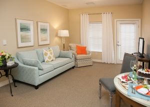 A cozy living room with a light blue sofa and matching chair, accented by warm lighting and modern decor.