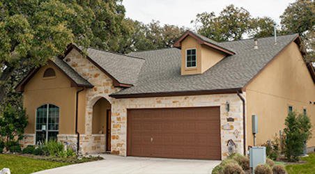 A modern house with a stone exterior and a double garage.