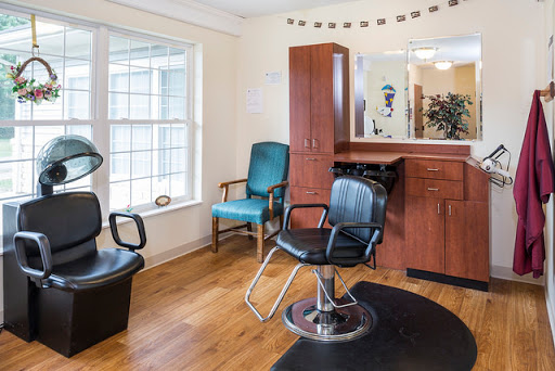A cozy hair salon featuring stylish seating and a well-organized layout.