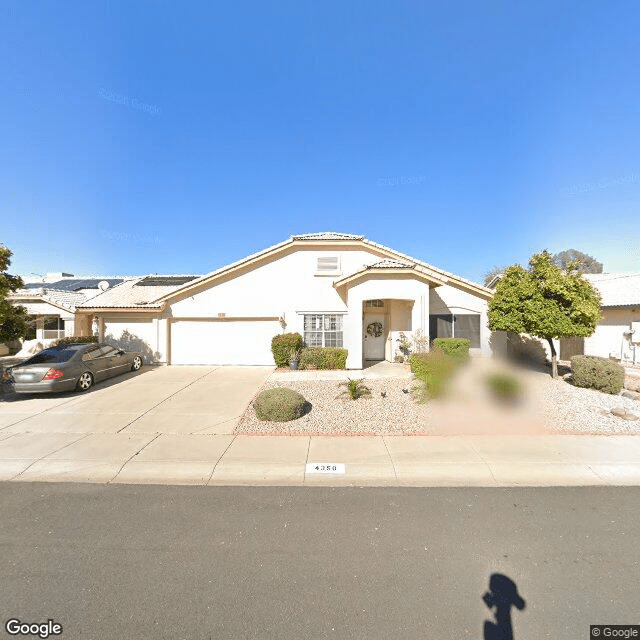 A suburban house with a driveway and car parked in front.