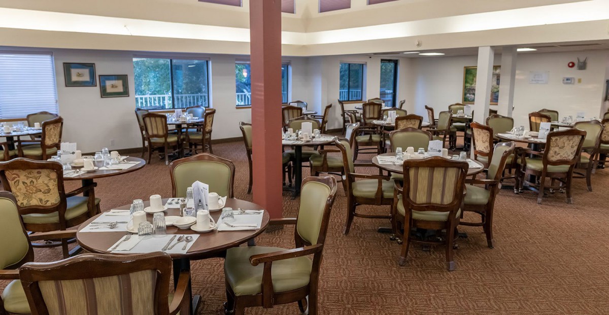 An elegantly set dining area with empty tables and chairs in a restaurant.