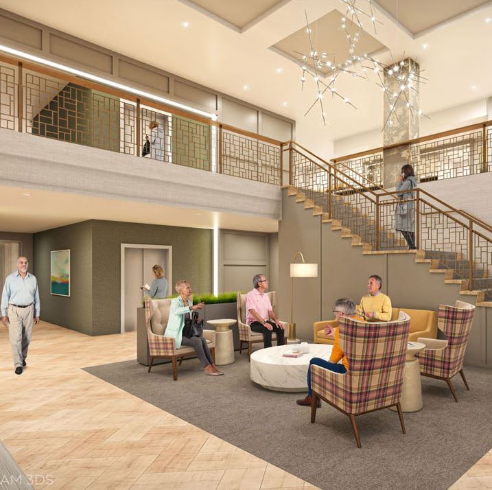 A modern lobby with a seating area and staircase, occupied by several people engaging in conversation.