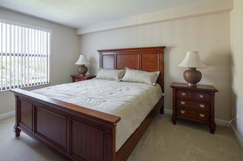 A well-furnished bedroom with a large bed, two nightstands, and lamps.