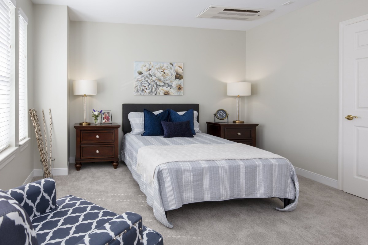 A well-decorated bedroom with a central bed, two nightstands, and stylish lamps.