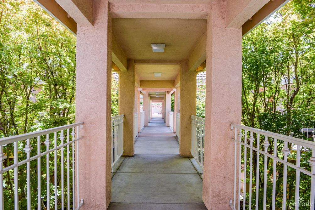 A long outdoor corridor with columns and railings, offering a perspective view.