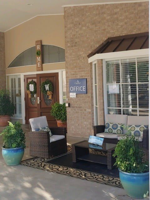 A welcoming building entrance with seating and plants.