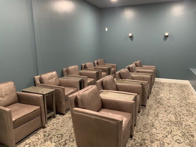 A neatly arranged waiting area with rows of armchairs and side tables.
