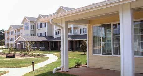 A view of residential buildings with a walkway and garden area.