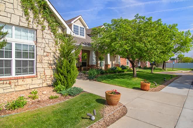 A well-maintained suburban house with a landscaped front yard and driveway.