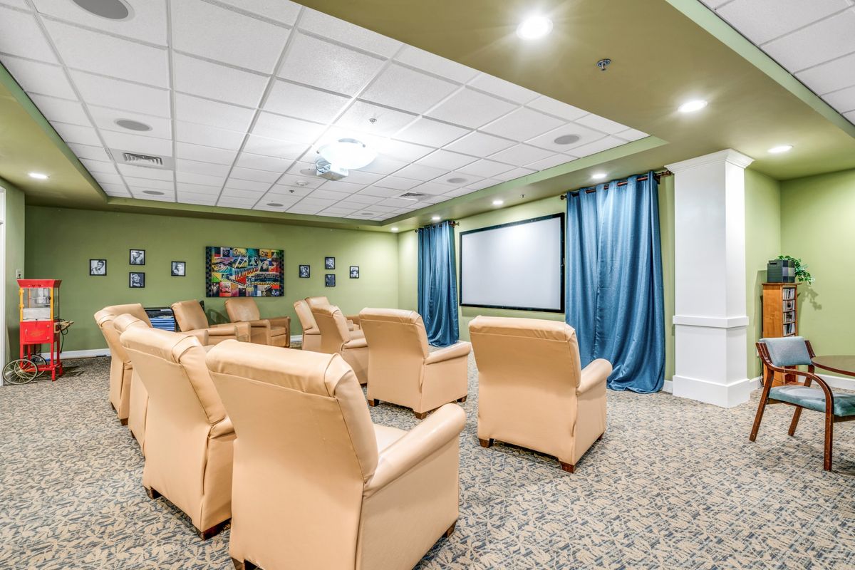 A cozy theater room with comfortable recliners facing a large projector screen.