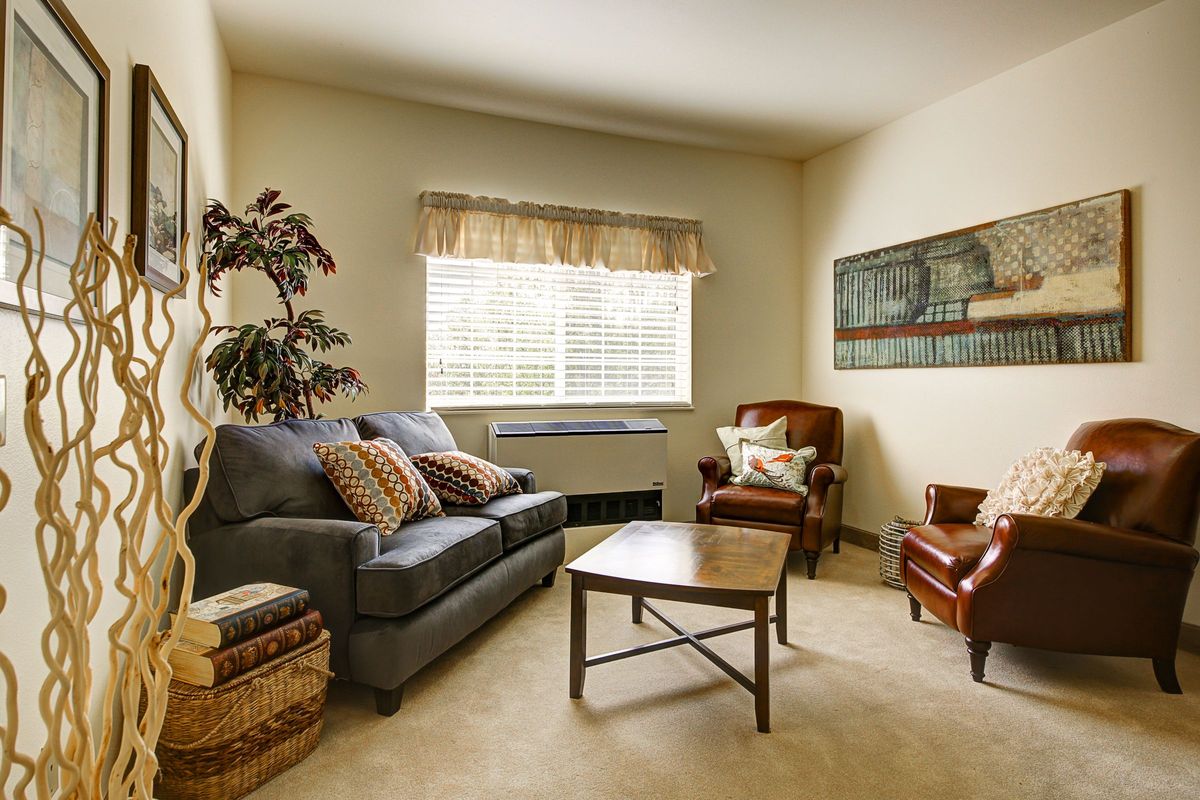 A cozy living room with a sofa, armchair, coffee table, and decor.