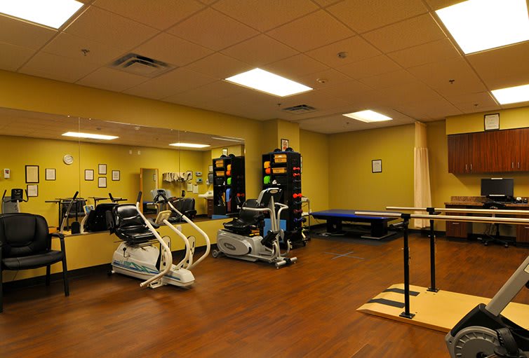 A rehabilitation room equipped with various exercise machines and therapy tools.