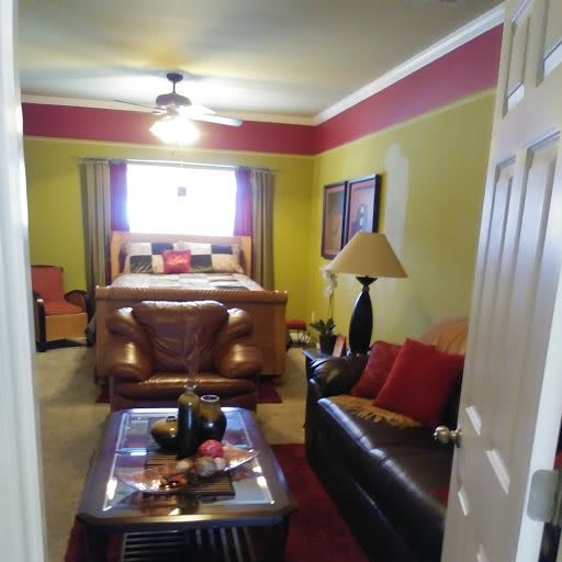 A cozy bedroom with colorful walls, featuring a bed, sofa, and decorative elements.