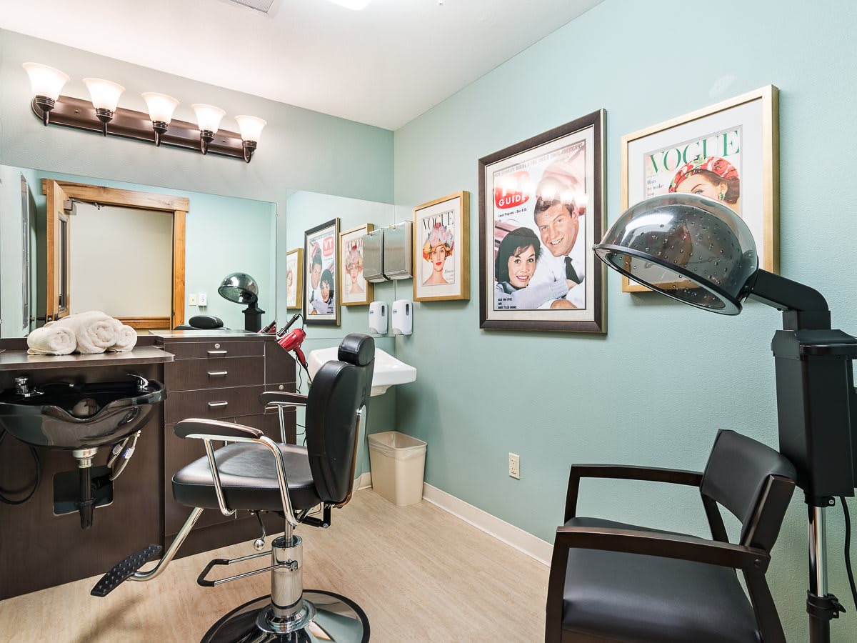 A cozy hair salon room with chairs, mirrors, and wall posters.