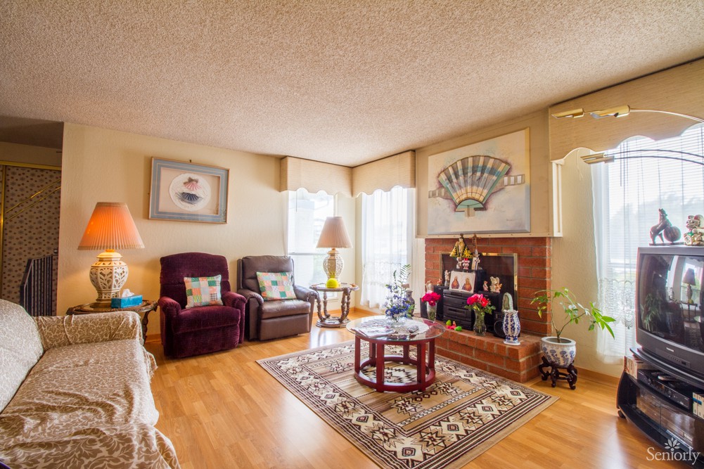 Cozy living room with armchairs, a fireplace, and a coffee table on a patterned carpet.