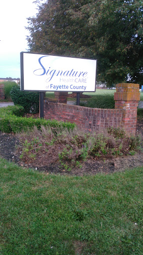 Entrance sign for Signature Care in Fayette County, featuring landscaped surroundings.