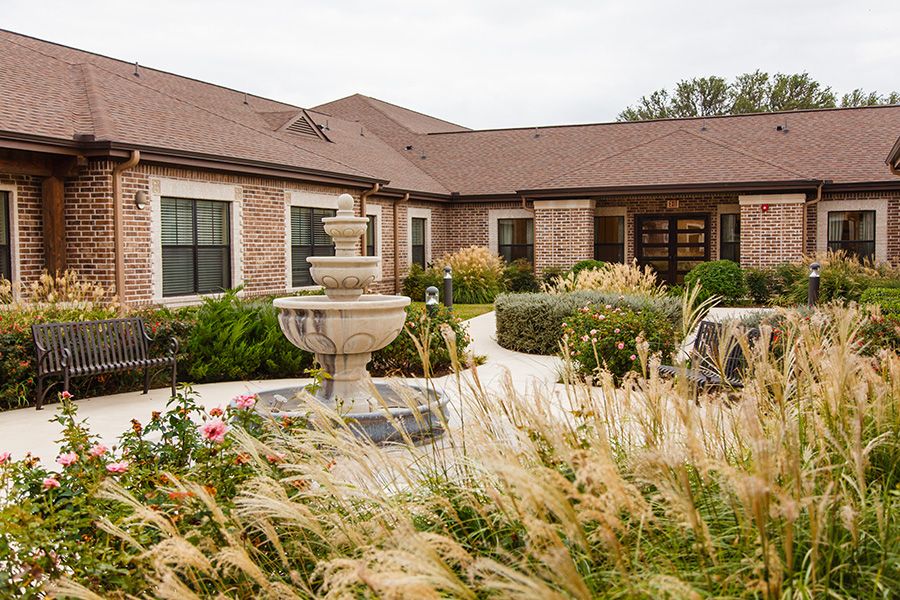A beautiful house with a well-maintained garden and a central fountain.