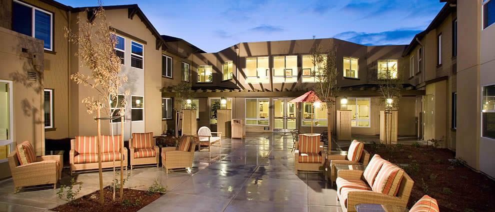 Evening view of a modern building with outdoor seating.