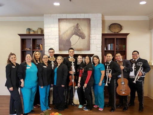 A joyful gathering of healthcare workers with a mariachi band, celebrating together.