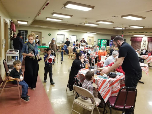 A vibrant community gathering with families and children enjoying activities and food.