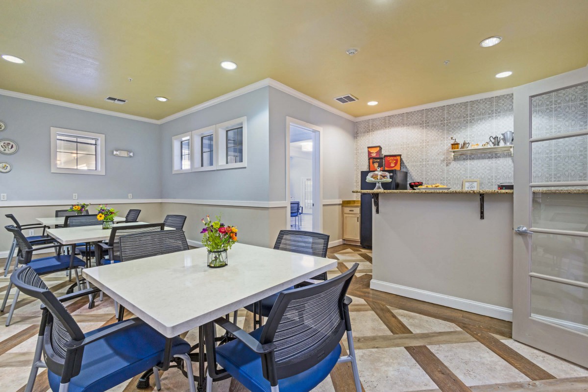 A cozy dining area with tables, chairs, and a coffee station.