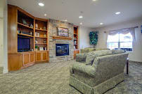 A cozy living room with a stone fireplace and comfortable seating.