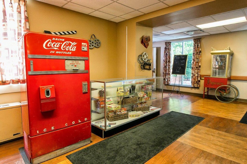 A vintage Coca-Cola vending machine and memorabilia display in a museum-like setting.