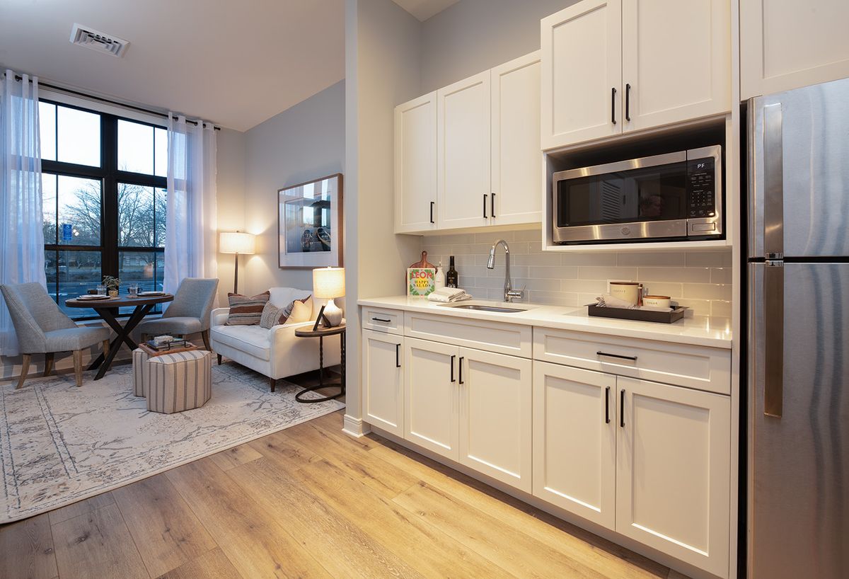 A modern apartment interior featuring a small kitchen and cozy living room area.