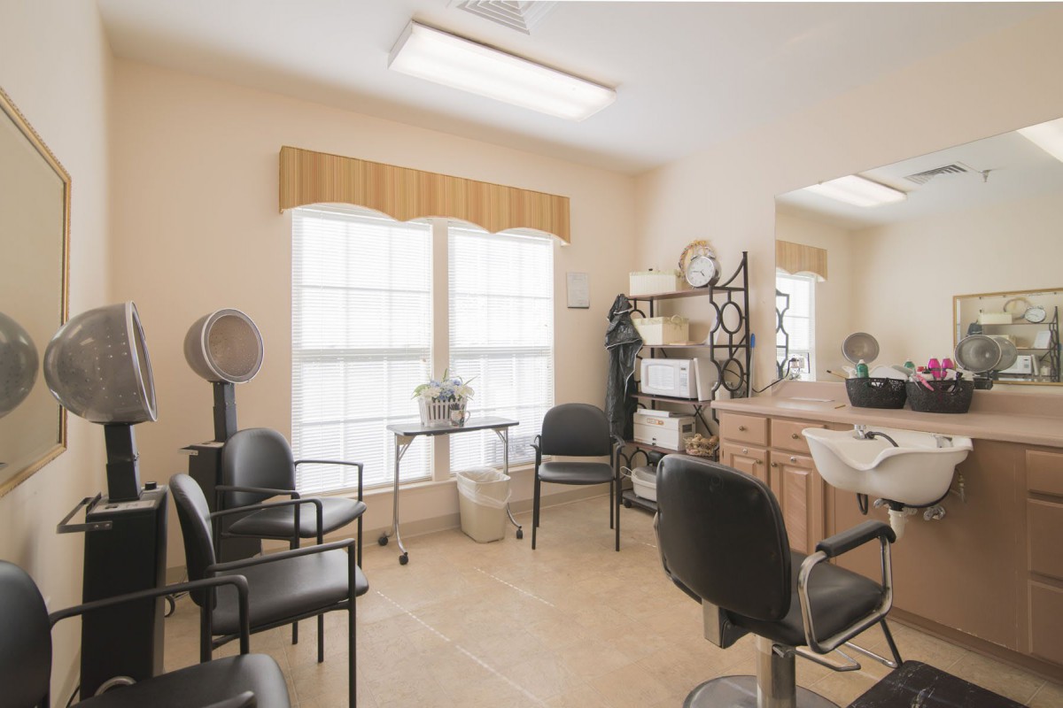 A small hair salon with chairs, hair dryers, and a waiting area.