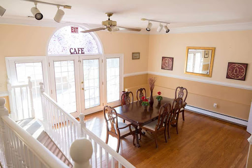 A spacious and inviting dining room with a wooden table set for gatherings, featuring natural light and tasteful decor.