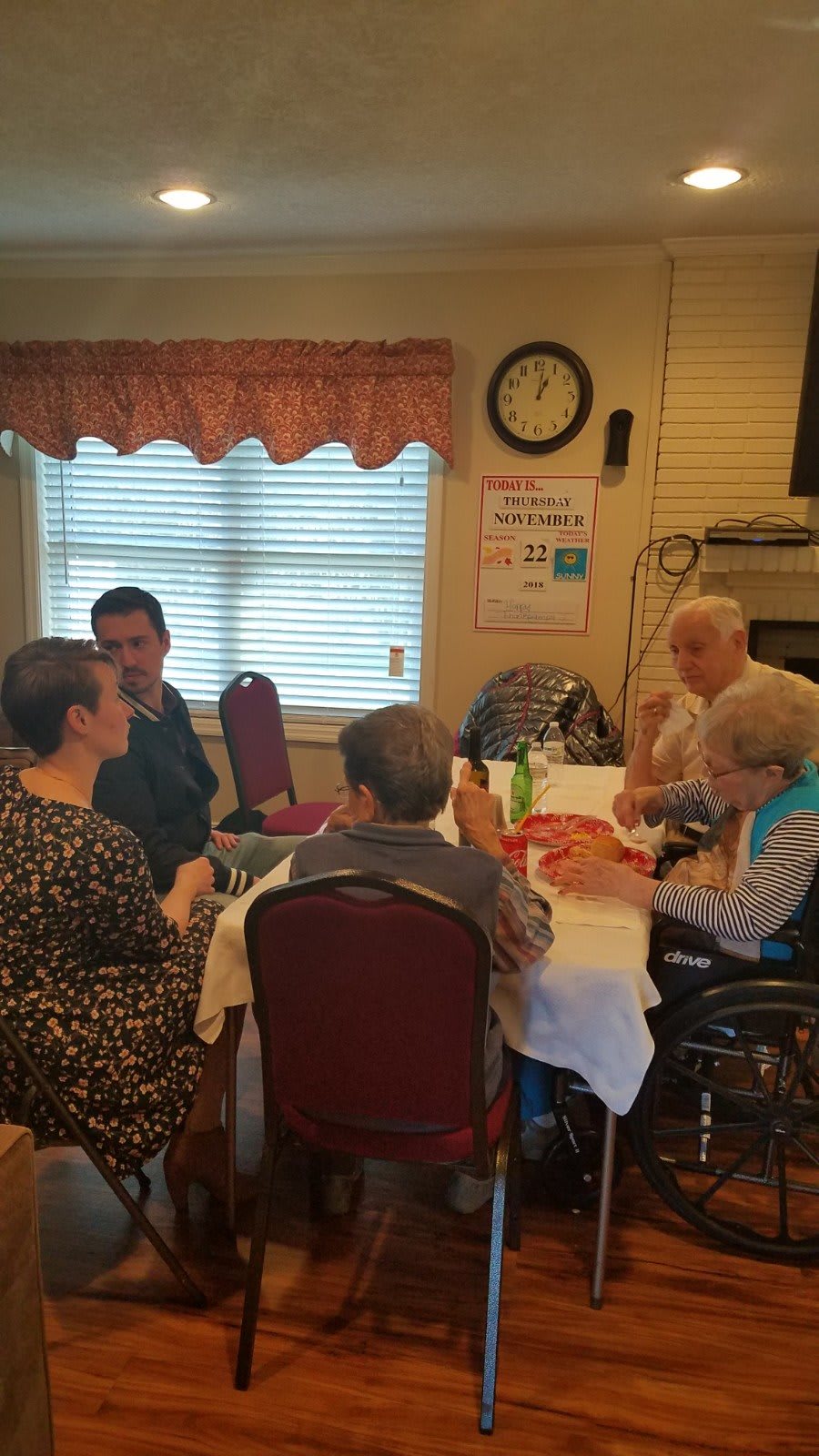 A group of people having a conversation around a table in a cozy indoor setting.