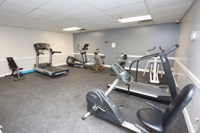 An indoor gym with various exercise machines including treadmills and stationary bikes.