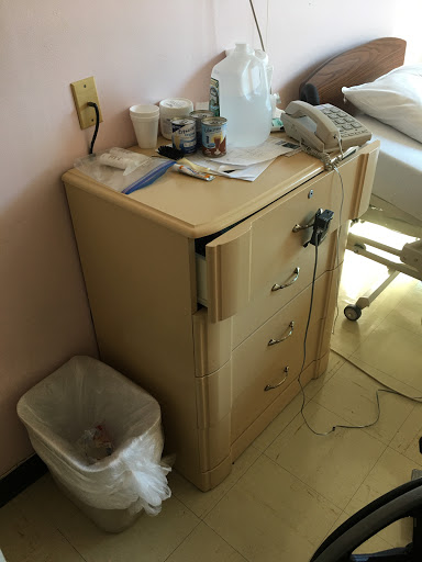 A bedside cabinet in a hospital room, used for storage and organization.