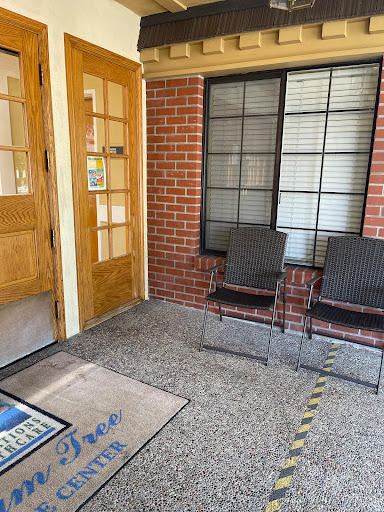 A welcoming entrance area featuring two chairs and a doormat.