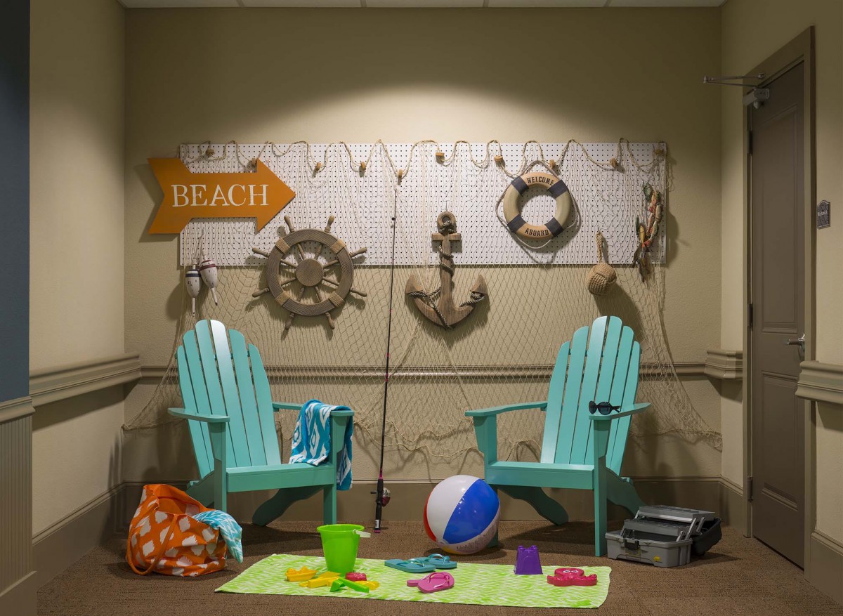 A cozy beach-themed setup with two chairs, nautical decorations, and beach accessories.