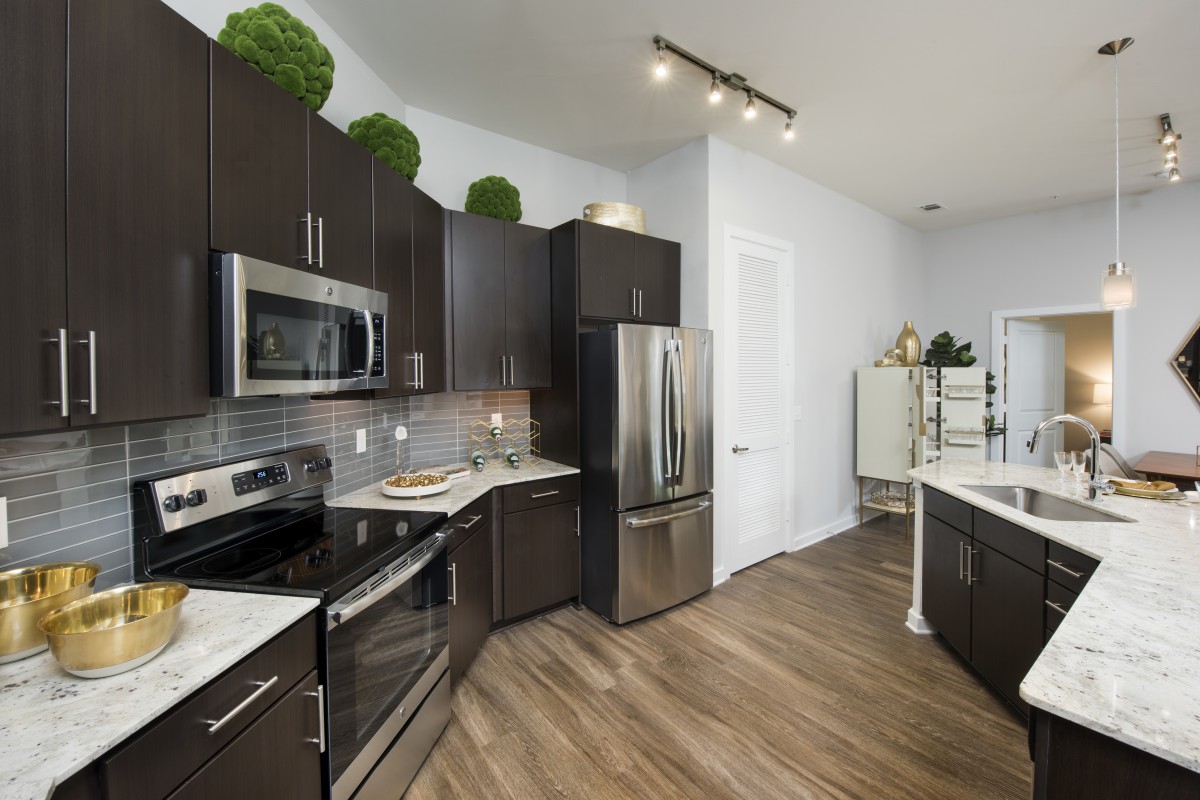 A modern kitchen with stainless steel appliances and dark cabinetry.