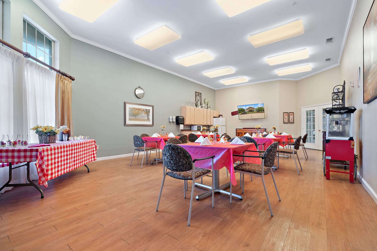 A decorated dining room with tables and chairs set up for an event.