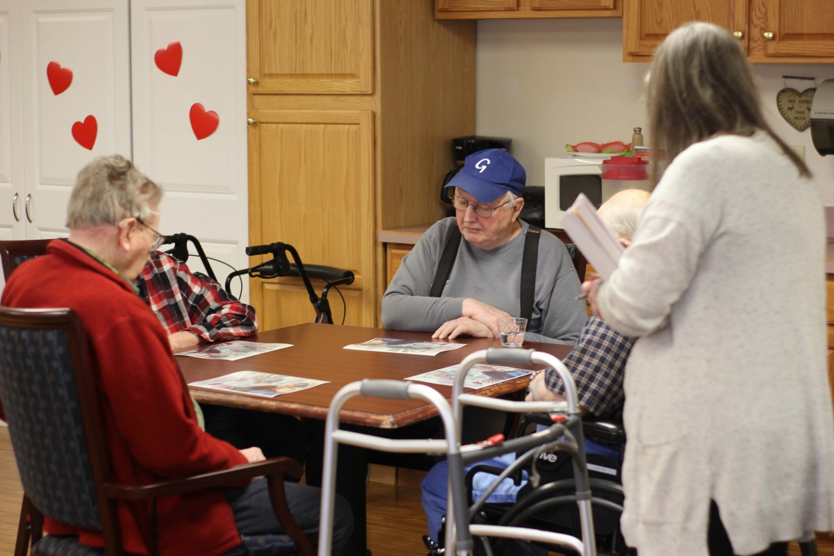 A group of seniors participating in a discussion at a care home.